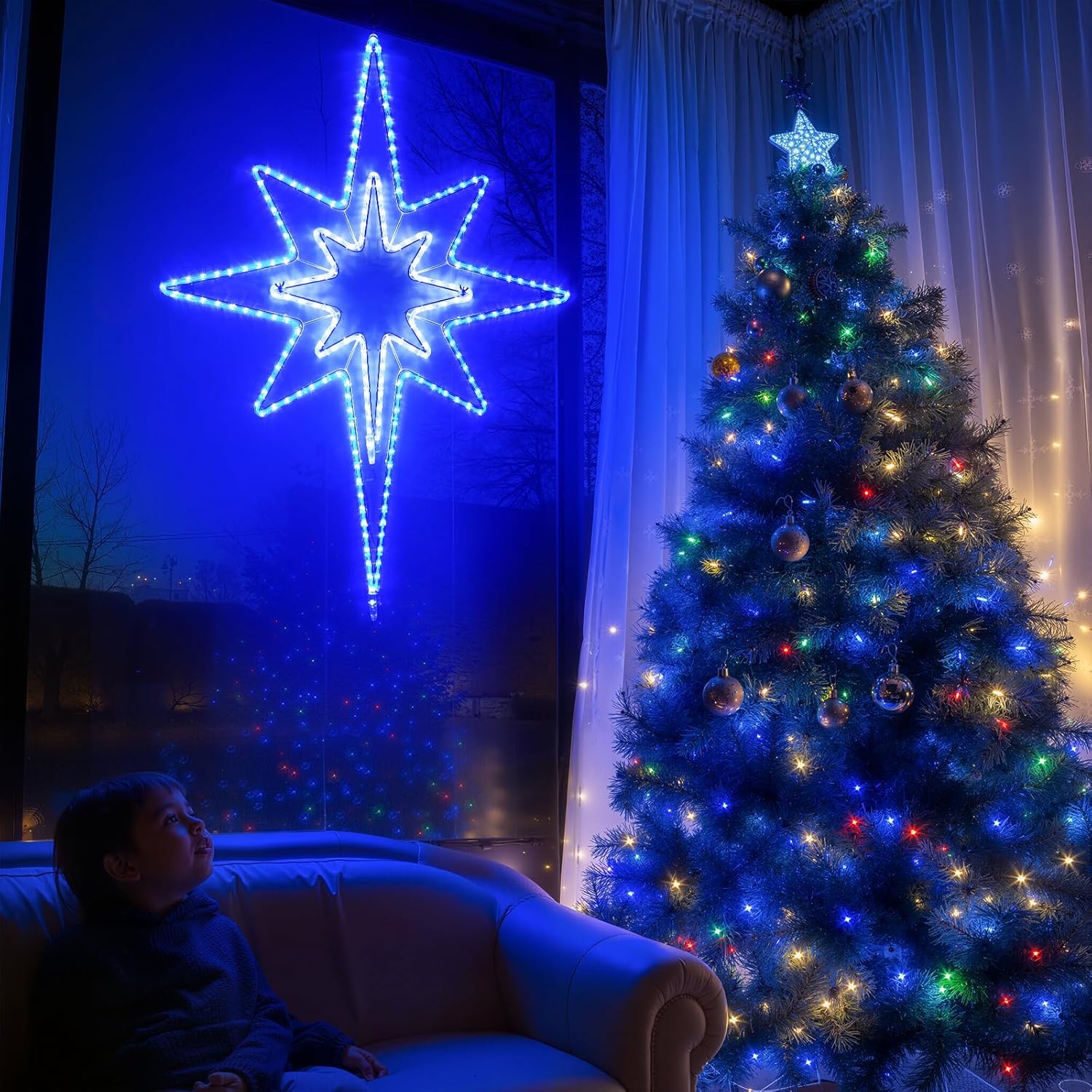 Person sitting on a couch in front of a decorated Christmas tree with a large blue star light fixture.