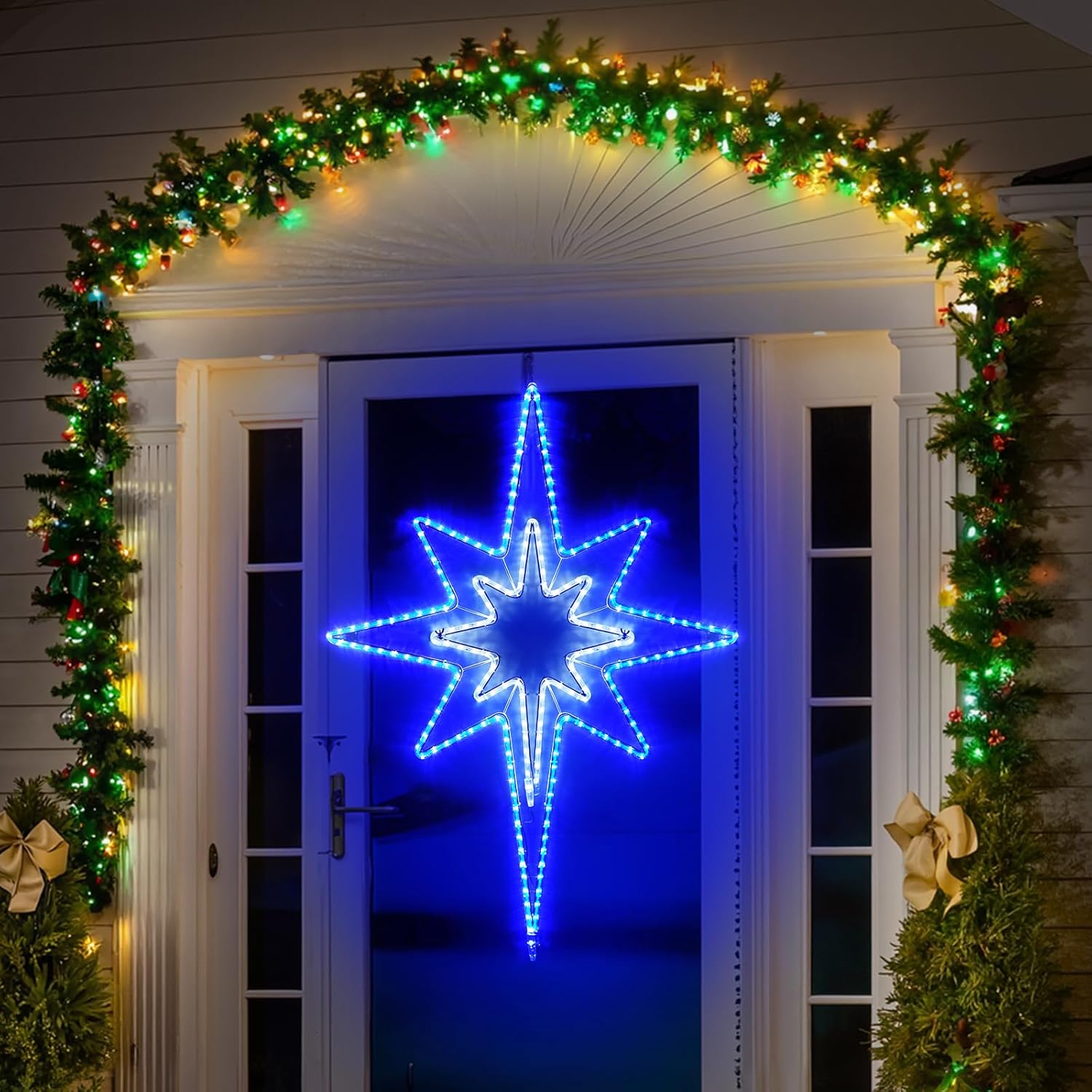 Decorative arch with greenery and lights above a door with a Star of Bethlehem LED star decoration