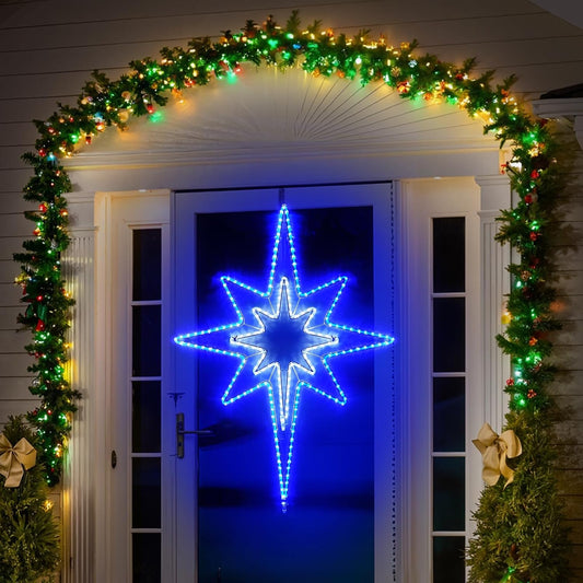 Decorative arch with greenery and lights above a door with a Star of Bethlehem LED star decoration